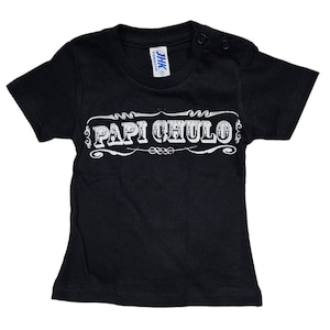 May include: Black short-sleeved t-shirt with a white graphic that says "Papi Chulo" in a vintage style font.