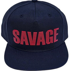 Könnte beinhalten: Marineblaue Snapback-Kappe mit dem Wort "SAVAGE" in roten, horizontal gestreiften Buchstaben auf der Vorderseite. Die Kappe hat einen flachen Schirm und einen Knopf oben.
