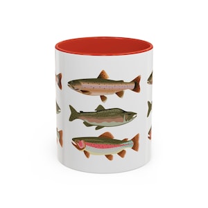 May include: White ceramic mug with a red rim, featuring a colorful illustration of five trout fish on a white background.