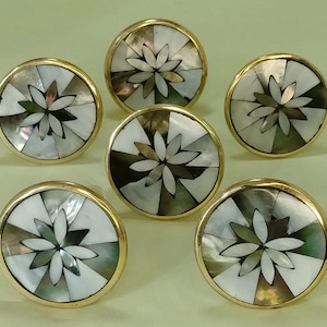 Può includere: Una tazza di ceramica bianca con manico nero e la scritta "But First, Coffee" in nero, in grassetto. La tazza è appoggiata su una superficie di legno. La tazza è alta circa 10 cm.