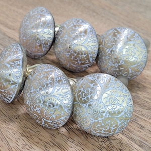 May include: Set of six ornate brass cabinet knobs with a white and gold floral design.