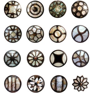 May include: A collection of decorative cabinet knobs with various designs. The knobs feature a mix of metallic bronze and iridescent mother-of-pearl inlays. The designs include geometric patterns, floral motifs, and circular shapes.