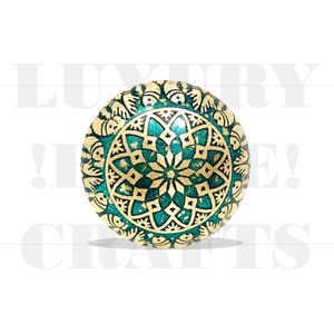 Puede incluir: Un adorno redondo, verde y dorado con un diseño de mandala. El adorno tiene un acabado brillante y metálico.
