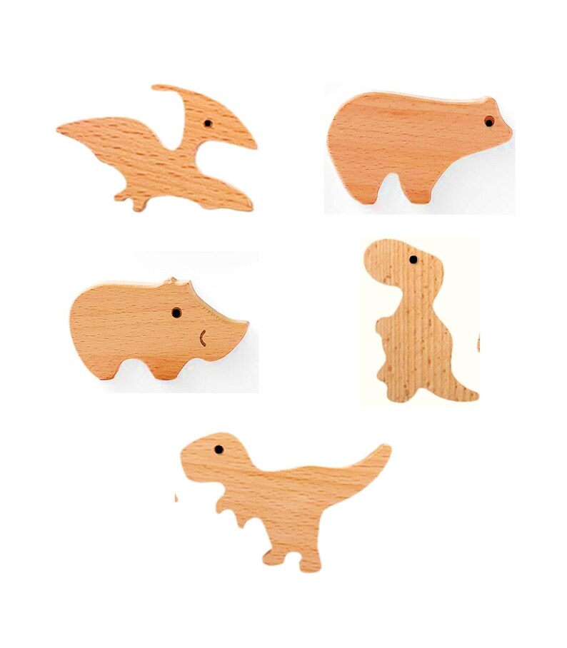 May include: Five wooden animal cutouts: a pterodactyl, bear, hippo, dinosaur, and T-Rex. Each cutout is made of light-colored wood with a smooth finish. The bear and hippo have simple, rounded shapes, while the dinosaurs have more detailed silhouettes.