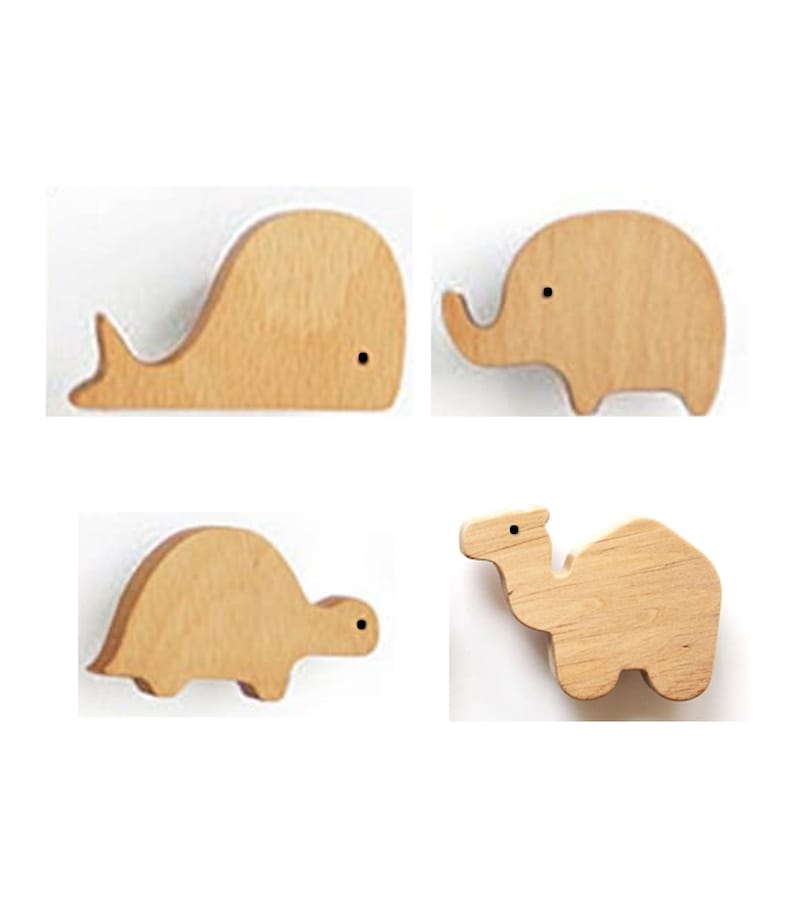 May include: Four wooden animal shapes: a whale, an elephant, a turtle, and a camel. Each animal is made of light-colored wood with a simple design and a small black dot for an eye. The shapes are arranged against a white background.