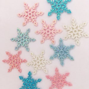 May include: A selection of glittery snowflake decorations in shades of pink, blue, and white. Each snowflake features a six-pointed design with detailed patterns. These ornaments are suitable for winter crafts and festive holiday decorations.