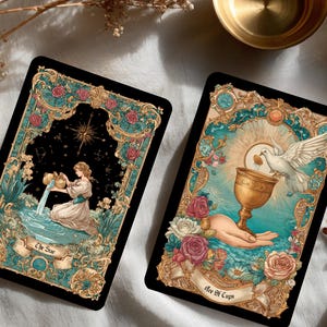 Puede incluir: Dos cartas de tarot con dise&ntilde;os florales y celestiales ornamentados. Una carta presenta a una mujer vertiendo agua, etiquetada como "The Sun". La otra muestra una mano sosteniendo un c&aacute;liz, con una paloma y el texto "Ace of Cups."