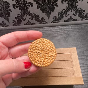 May include: A round woven wicker chair seat in a natural brown color.