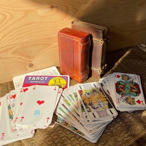 Baraja de tarot Grimaud de los años 60 compuesta por sus 78 cartas y su estuche libro de piel personalizado.