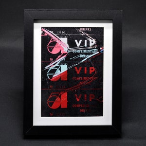 Puede incluir: Una impresión enmarcada en blanco y negro de tres pases VIP vintage con acentos rojos y azules. Los pases son para bebidas de cortesía y presentan el texto "VIP" y "Bebidas de cortesía".