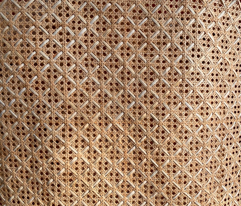 Peut inclure: Gros plan sur un mat&eacute;riau en rotin ou en cannage tiss&eacute; avec un motif en losange. Le mat&eacute;riau est brun clair et a un aspect naturel et rustique.