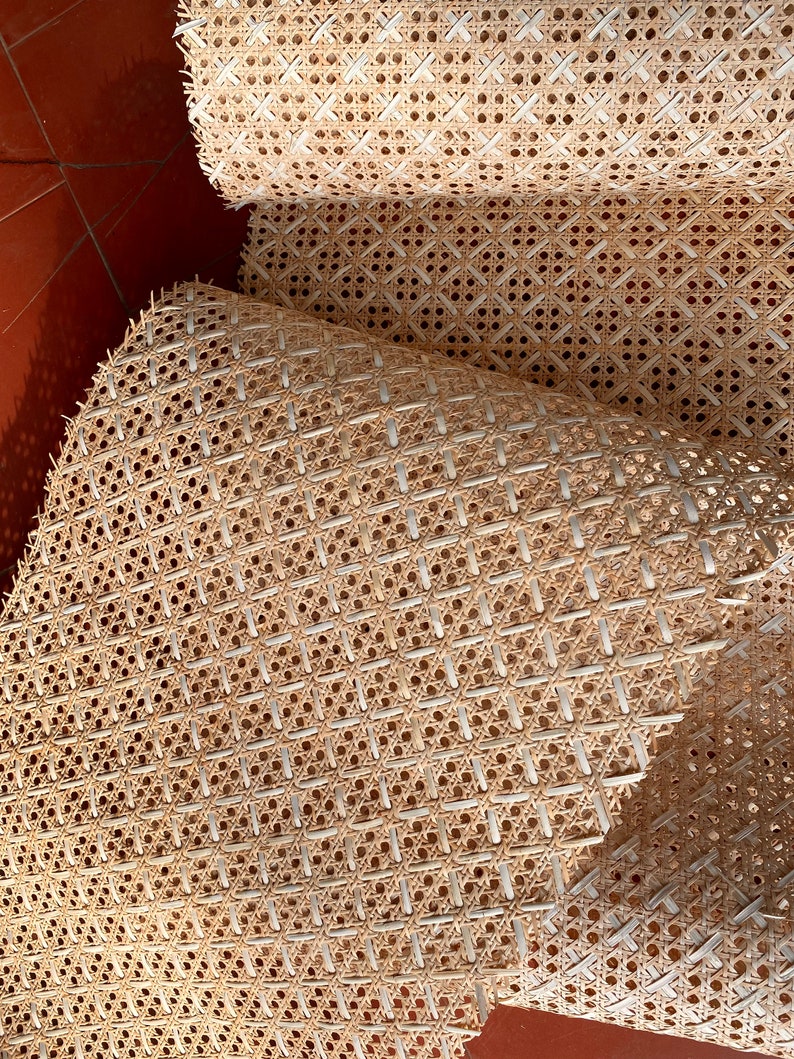 Peut inclure: Gros plan sur un mat&eacute;riau de tissage en rotin, souvent utilis&eacute; pour les si&egrave;ges et les dossiers de chaises. Le mat&eacute;riau est brun clair et pr&eacute;sente un motif en losange.