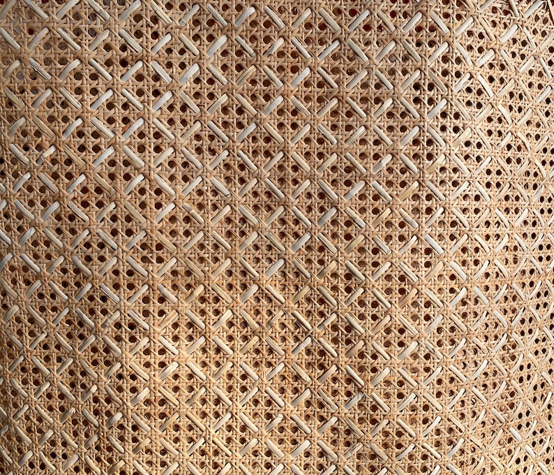 Peut inclure: Gros plan sur un mat&eacute;riau en rotin ou en cannage tiss&eacute; avec un motif en losange. Le mat&eacute;riau est brun clair et a un aspect naturel et rustique.