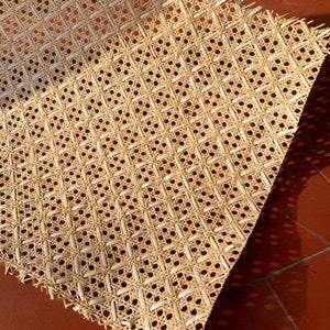 Peut inclure: Un plan rapproch&eacute; d'une feuille de cannage tiss&eacute;, souvent utilis&eacute;e pour les si&egrave;ges et les dossiers de chaises. Les couleurs brunes et beiges naturelles cr&eacute;ent un aspect rustique et traditionnel.