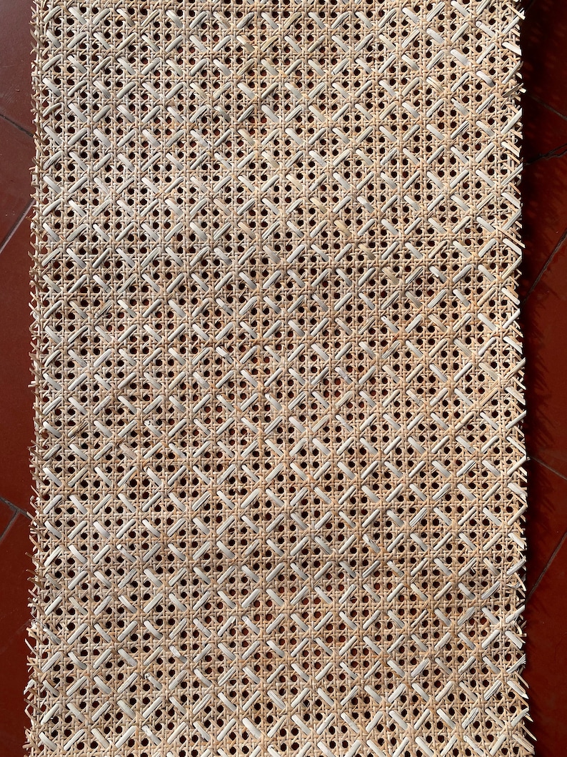 Peut inclure: Un gros plan sur un mat&eacute;riau de tissage en rotin. Le mat&eacute;riau est fait de rotin naturel et a une couleur brun clair. Le tissage est un motif en losange simple.