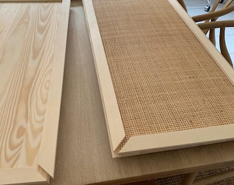 Könnte beinhalten: Zwei Holzrahmen, einer mit natürlicher Holzoptik und der andere mit einem gewebten Stoffeinsatz. Die Rahmen befinden sich auf einem hellen Holztisch.