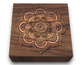 Può includere: Un blocco quadrato di legno con un design di mandala intagliato al centro. Il mandala è intricato e dettagliato, di colore marrone.