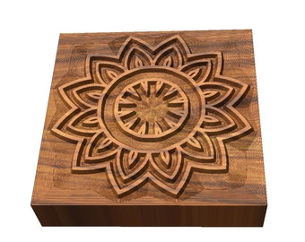 May include: A square wooden decorative piece with a carved floral design. The design features a central circular element surrounded by layered petal shapes. The wood has a warm, natural tone, and the carving creates depth and shadow.