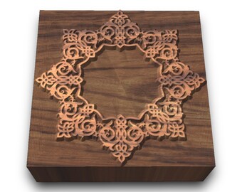 May include: A wooden box with a decorative, intricate, carved design in the center. The design is a light brown color and is raised from the surface of the box.