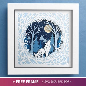 May include: A framed paper art piece depicting a howling wolf under a full moon in a forest scene. The artwork is layered with shades of blue and white, creating a 3D effect. The frame is white, and the background is a solid blue.