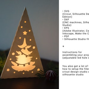 May include: A white papercraft Christmas tree with a cut-out design of a Christmas tree with lights and ornaments. The tree is lit from behind, creating a warm glow. The image includes instructions for assembling the project and tips for setting up the files in Cricut Design Studio or Silhouette Studio.