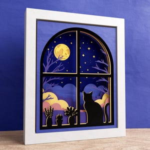 May include: A white frame with a blue background and a black window with a cat silhouette looking out at a yellow moon and stars. The window is arched and has a layered paper design.