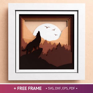 May include: A framed, layered paper art piece depicting a howling wolf silhouette on a rocky outcrop, set against a forest and a full moon. The artwork is in shades of brown and tan, with a white frame. Text at the bottom reads "+ FREE FRAME • SVG, DXF, EPS, PDF •".