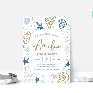 May include: A personalized invitation with a seashell theme. The invitation features the text "Let's Shellabrate! Amelia is turning five!" with the date, time, and location. The design includes illustrations of seashells, starfish, and bubbles in blue, gold, and lavender.