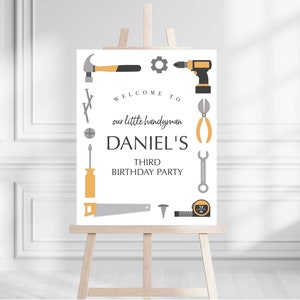 Puede incluir: Un cartel de bienvenida blanco con un tema de caja de herramientas gris y amarillo. El cartel dice "Bienvenido a nuestro pequeño manitas Daniel's Tercer Cumpleaños".