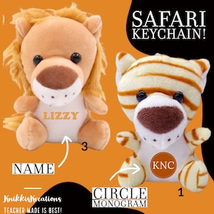 May include: Two plush safari animal keychains. One is a lion with the name "LIZZY" on its belly. The other is a tiger with the initials "KNC" in a circle. The text "SAFARI KEYCHAIN!" is above the animals.