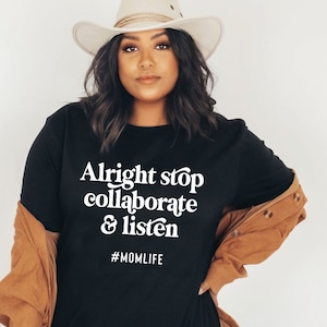 May include: Black t-shirt with white text that reads "Alright stop collaborate & listen" and the hashtag "#MOMLIFE".