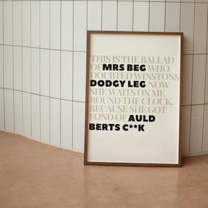 May include: A framed print with a white background and black text. The text reads "This is the ballad of Mrs Beg who doubted Winstons Dodgy Leg now she waits on me round the clock. Because she got fond of Auld Berts C**k."