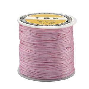 May include: A spool of pink waxed cord, with a label in Chinese characters that reads "Chinese Waxed Cord".