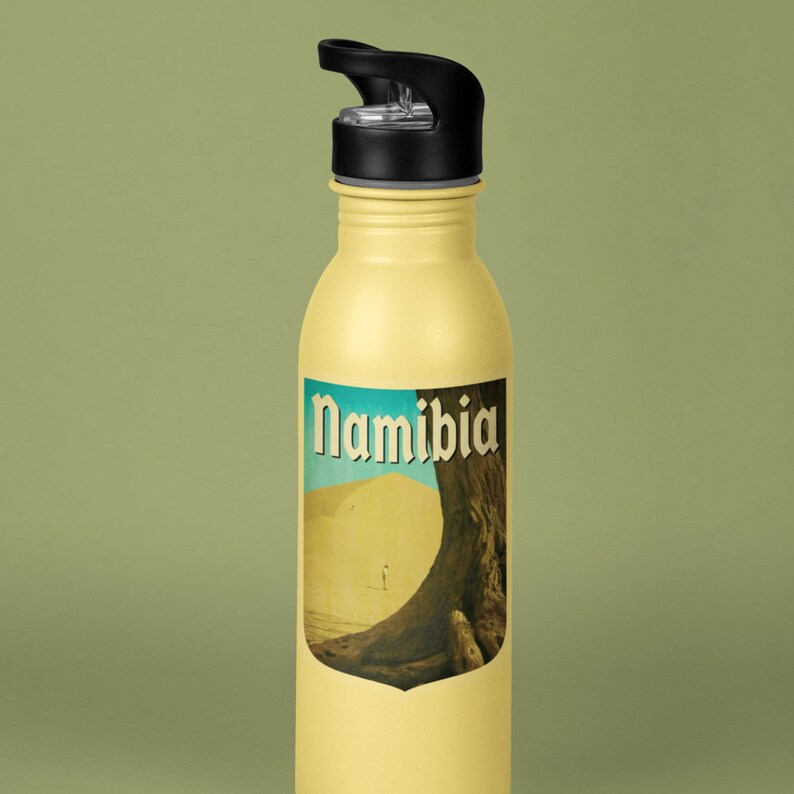 K&ouml;nnte beinhalten: Eine gelbe Wasserflasche mit schwarzem Deckel und einem Aufkleber mit einer W&uuml;stenlandschaft und dem Wort "Namibia".