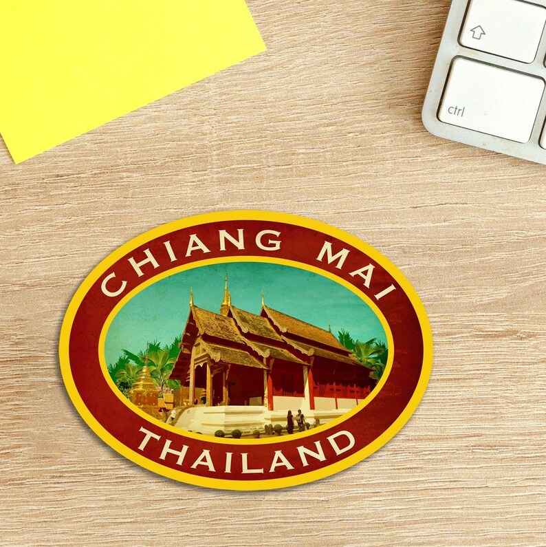 May include: A vintage-style round sticker with a red border and yellow outer ring. The sticker features a colorful illustration of a traditional Thai temple with the text "CHIANG MAI THAILAND" in a gold font.