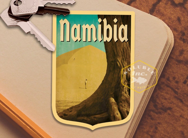 K&ouml;nnte beinhalten: Ein Vintage-Reiseposter mit einer gro&szlig;en Sandd&uuml;ne und einem Baum mit dem Wort "Namibia" in fetter, stilisierter Schrift.
