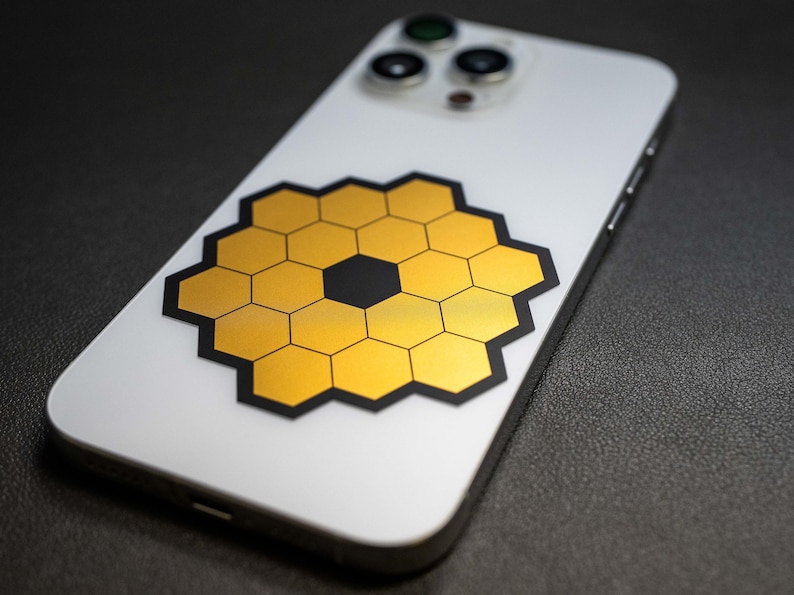 May include: A white smartphone with a black and gold honeycomb design sticker on the back.