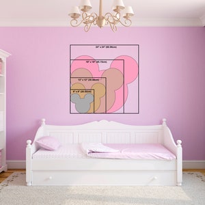K&ouml;nnte beinhalten: Eine rosa Wand mit einem wei&szlig;en Tagesbett und einer Reihe von Mickey-Maus-Kopf-Silhouetten in verschiedenen Gr&ouml;&szlig;en. Die Silhouetten sind mit ihren Abmessungen in Zoll und Zentimetern beschriftet.