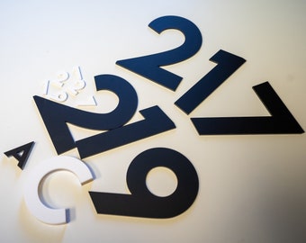 May include: Black and white numbers and letters, including the letters "A" and "C" and the numbers "1", "2", "6", "7", and "9".
