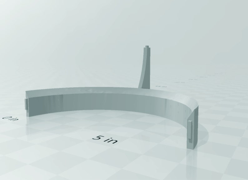 May include: A 5-inch diameter, gray, semi-circular, plastic ring with a tall, gray, plastic tower in the center.