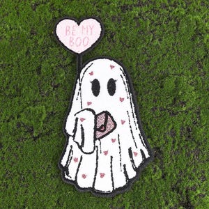 May include: A white ghost with pink hearts and the text "Be My Boo" on a pink heart above it.