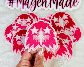 May include: A stack of pink and white iron-on patches with a white star and bird design. The patches have a jagged edge and say "#MagenMade" on the top.