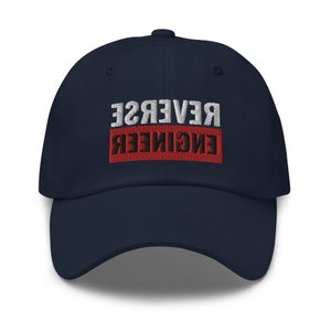 May include: A navy blue baseball cap with the text "REVERSE ENGINEER" embroidered in white and black on a red background.