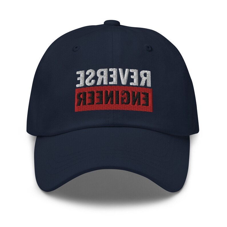 May include: A navy blue baseball cap with the text "REVERSE ENGINEER" embroidered in white and black on a red background.