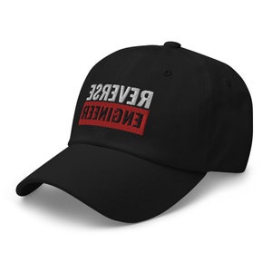 May include: A black baseball cap with the text "REVERSE ENGINEER" embroidered in white and red on the front.