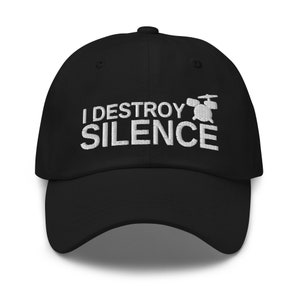 Op de afbeelding: Zwarte baseballpet met witte geborduurde tekst die "I DESTROY SILENCE" luidt en een kleine witte drumgrafiek.