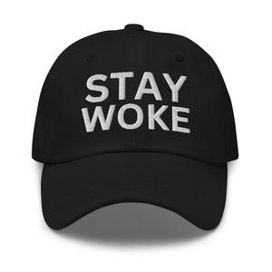 Könnte beinhalten: Schwarze Baseballkappe mit dem gestickten Text "STAY WOKE" in Weiß. Die Kappe hat einen gebogenen Schirm und eine strukturierte Passform. Ein klassisches und vielseitiges Accessoire.