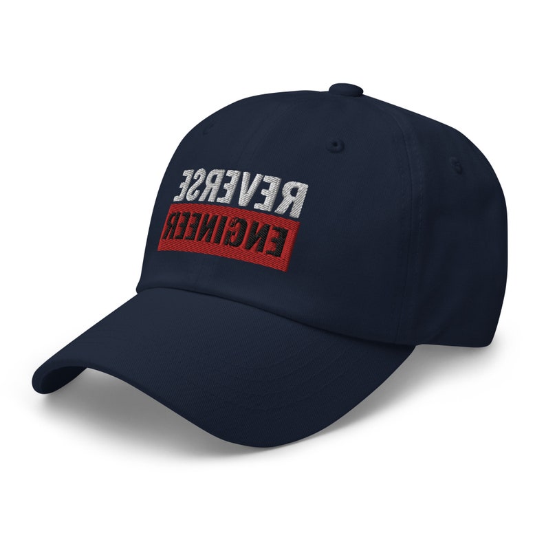 May include: A navy blue baseball cap with the text "REVERSE ENGINEER" embroidered in white and black on a red rectangle.