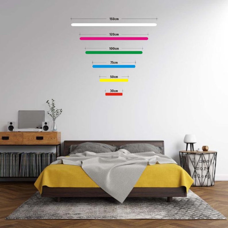K&ouml;nnte beinhalten: Eine wei&szlig;e Wand mit f&uuml;nf horizontalen Linien in verschiedenen Farben und L&auml;ngen. Die Linien sind mit ihren L&auml;ngen in Zentimetern beschriftet: 150 cm, 120 cm, 100 cm, 75 cm, 50 cm und 30 cm. Die Linien sind wei&szlig;, rosa, gr&uuml;n, blau, gelb und rot.
