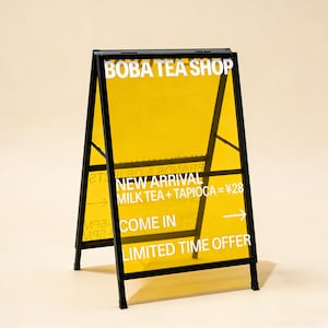 May include: A-frame sign for a Boba Tea Shop. The sign has a black metal frame with yellow translucent panels. White text on the panels reads "BOBA TEA SHOP", "NEW ARRIVAL", "MILK TEA + TAPIOCA = ¥28", "COME IN", and "LIMITED TIME OFFER".